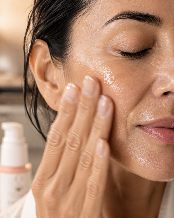 Fingerspitzen massieren Serum in Wange, glänzende Haut