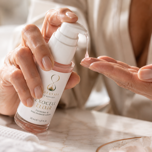 Hände mit Exocell Elixir Flasche, zartrosa Serum Tropfen